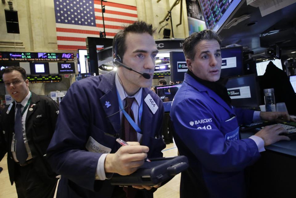 Gregory Rowe, center, places orders for stock with Anthony Rinaldi, right, at the New York Stock Exchange, Wednesday, Feb. 12, 2014. U.S. stocks are edging higher in early trading as the market extends its longest winning streak of the year. (AP Photo/Mark Lennihan)