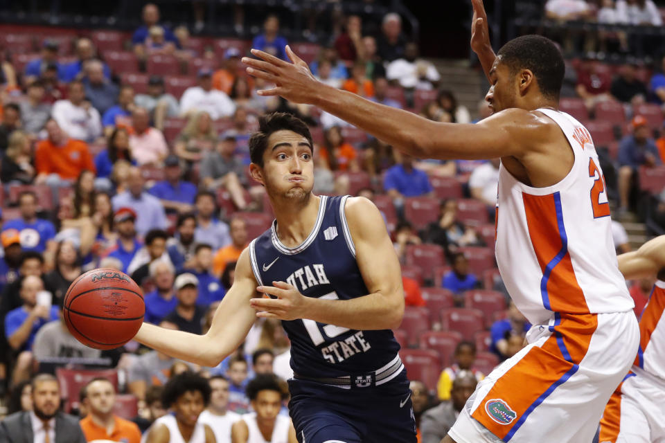 Utah State guard Abel Porter (15) passes past Florida forward Kerry Blackshear Jr. in the first half of an NCAA college basketball game, part of the Orange Bowl Classic tournament, Saturday, Dec. 21, 2019, in Sunrise, Fla. (AP Photo/Wilfredo Lee)