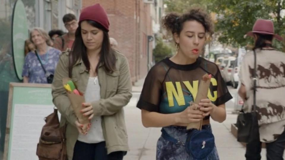 Ilana and Abbi with their colorful churrons on a New York City street on Broad City
