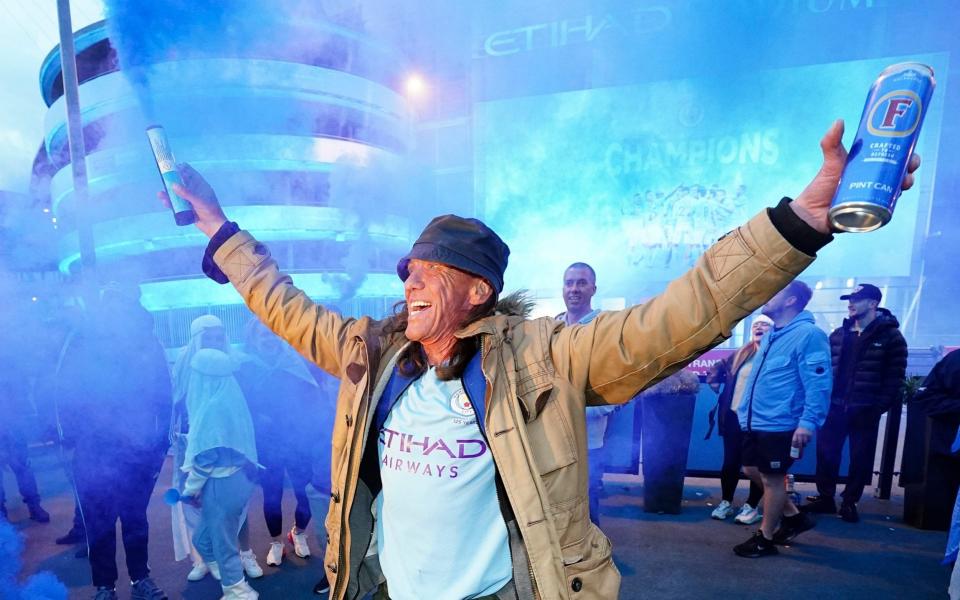 A Manchester City supporter celebrates  - AP