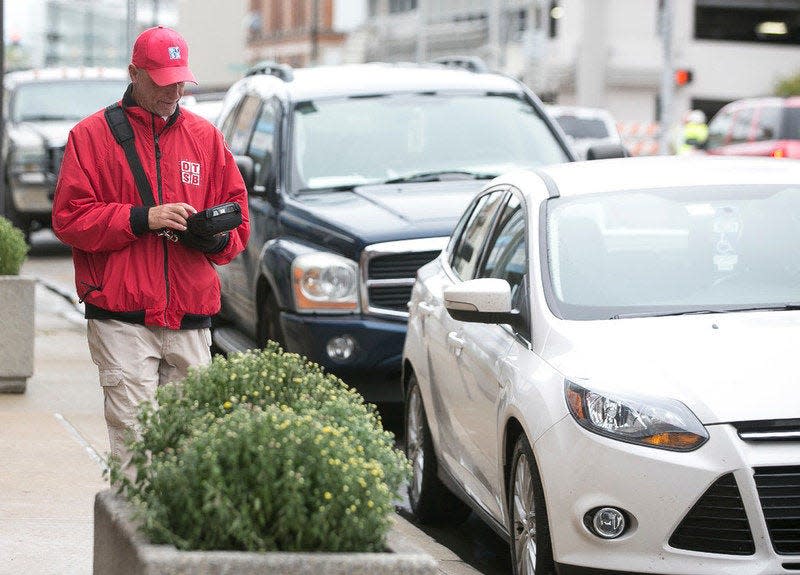 A DTSB employee walks around downtown South Bend keeping track of cars parked in the parking zones last fall.Tribune File Photo/SANTIAGO FLORES