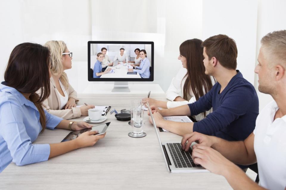 Two groups of people talking to the other in a Zoom Video video conference.