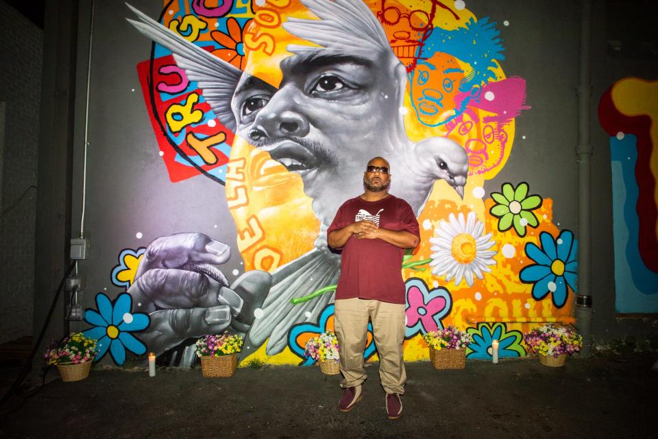 DJ Maceo stands in front of a mural painted by artist Tristan Eaton at the Museum of Graffiti pop up exhibit in Austin. The mural was unveiled at a tribute to Trugoy, an emcee with the group who recently died at 54.