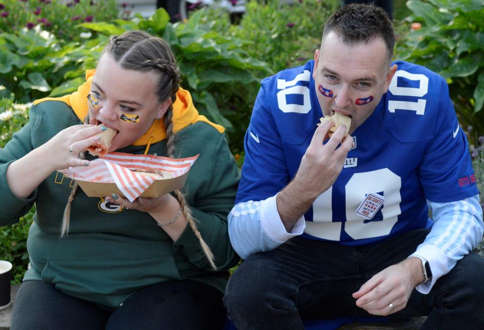 Danielle Morgan and Rhys Morgan of Cannock, England, eat food purchased from a nearby vendor, which pretty well sums up the extent of tailgating around Tottenham Hotspur Stadium in London.