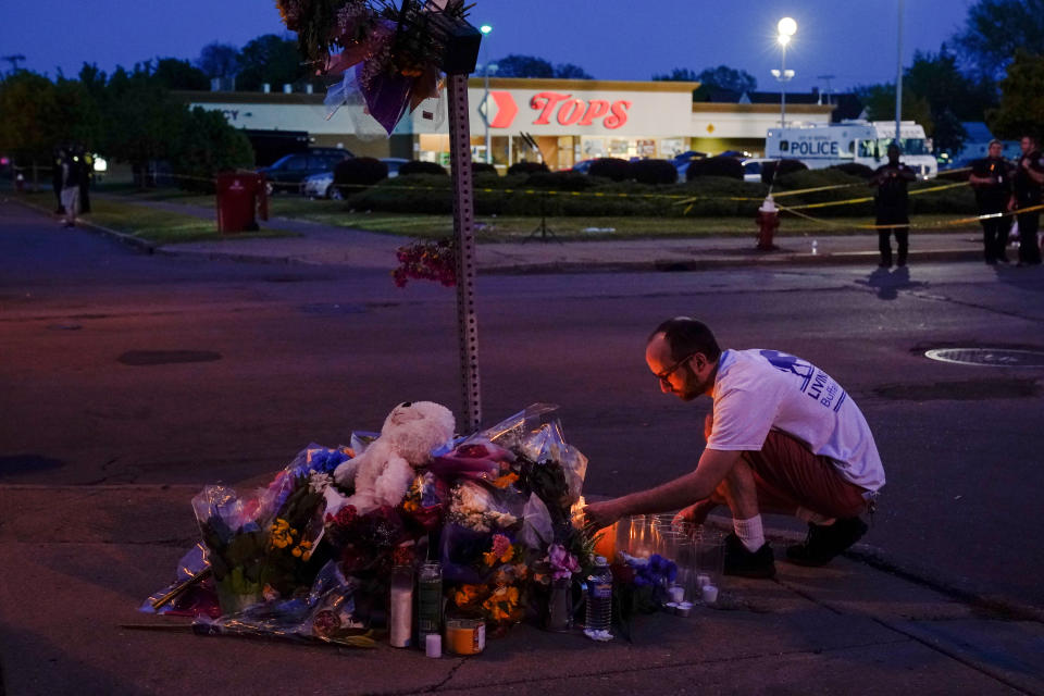 FILE - A person pays his respects at a makeshift memorial outside the scene of a shooting at a supermarket in Buffalo, N.Y., Sunday, May 15, 2022. (AP Photo/Matt Rourke, File)