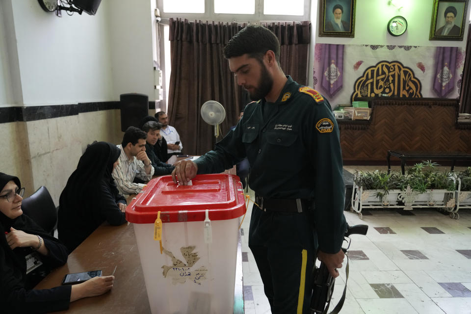 An Iranian policeman casts his vote for the presidential runoff election at a polling station in Tehran, Iran, Friday, July 5, 2024. Iranians began voting Friday in a runoff election to replace the late President Ebrahim Raisi, killed in a helicopter crash last month, as public apathy has become pervasive in the Islamic Republic after years of economic woes, mass protests and tensions in the Middle East. (AP Photo/Vahid Salemi)