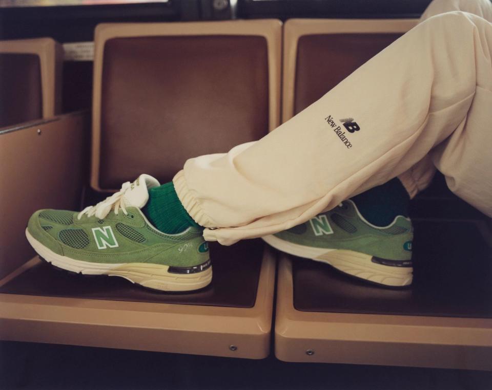a pair of white and green sneakers on a shelf