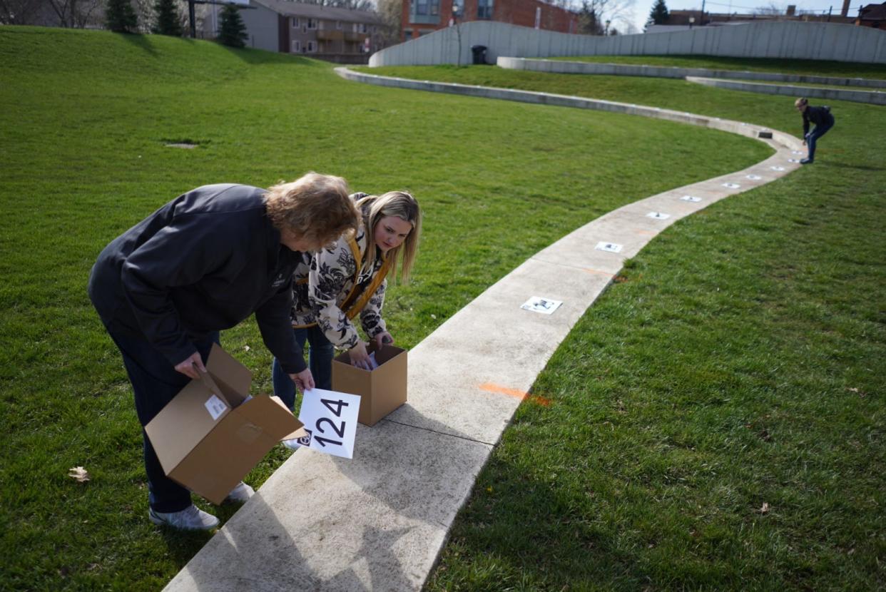 Director of marketing destination for Seneca County Marisa Stephens, right, and director of operations Deb Matorana set places for some of the 130 registered couples before the start of the Elope at the Eclipse event at the Frost Kalnow Amphitheater in Tiffin, OH on Monday, April 8, 2024.