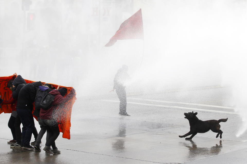 Student protesters are hit by a jet of water as they clash with riot policemen during a demonstration against the government to demand changes in the public state education system in Santiago, August 23, 2012. Chilean students have been protesting against what they say is profiteering in the state education system. REUTERS/Ivan Alvarado (CHILE - Tags: POLITICS CIVIL UNREST EDUCATION TPX IMAGES OF THE DAY)