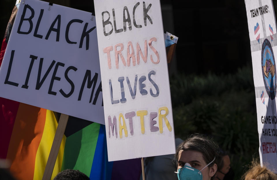 Members of the Team Trans protest outside the Netflix building on Vine Street in the Hollywood section of Los Angeles, Wednesday, Oct. 20, 2021. Critics and supporters of Dave Chappelle's Netflix special and its anti-transgender comments gathered outside the company's offices Wednesday, with "Trans Lives Matter" and "Free Speech is a Right" among their competing messages. (AP Photo/Damian Dovarganes)