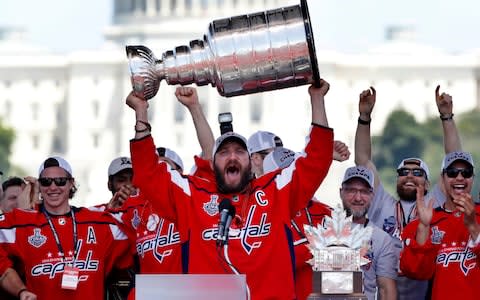Alexander Ovechkin, from Russia, holds up the Stanley Cup trophy during the NHL hockey team's Stanley Cup victory celebration in Washington - Credit: Jacquelyn Martin/AP