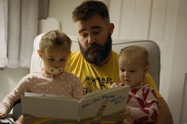 <p>Amazon Studios</p> Jason Kelce reading to daughters Elliotte and Wyatt