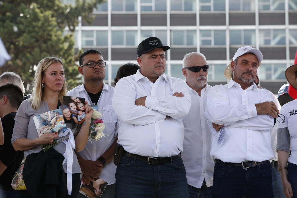 Adriana LeBaron, left, Julian LeBaron, center, and Adrian LeBaron, right, stand during a protest against the first year in office of Mexico's President Andres Manuel Lopez Obrador, in Mexico City, Monday, Dec. 1, 2019. The LeBaron's joined a protest on Reforma avenue to expressed anger and frustration over increasingly appalling incidents of violence, a stagnant economy and deepening political divisions in the country. (AP Photo/Ginnette Riquelme)