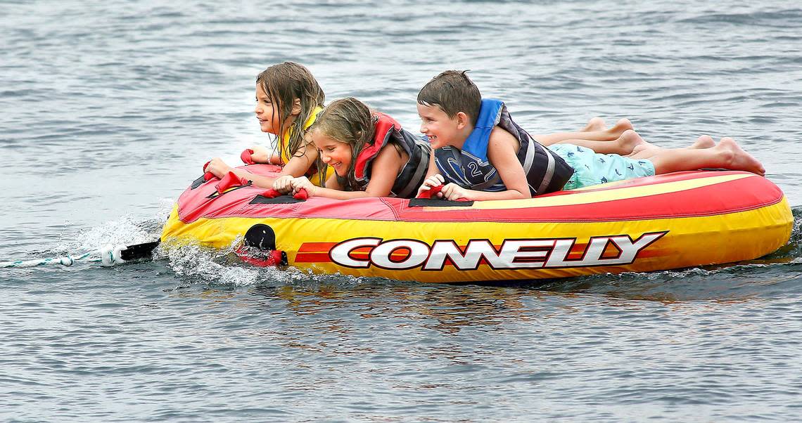 Kids enjoy a wavy ride behind a boat on the Columbia River on a hot Tri-Cities day.