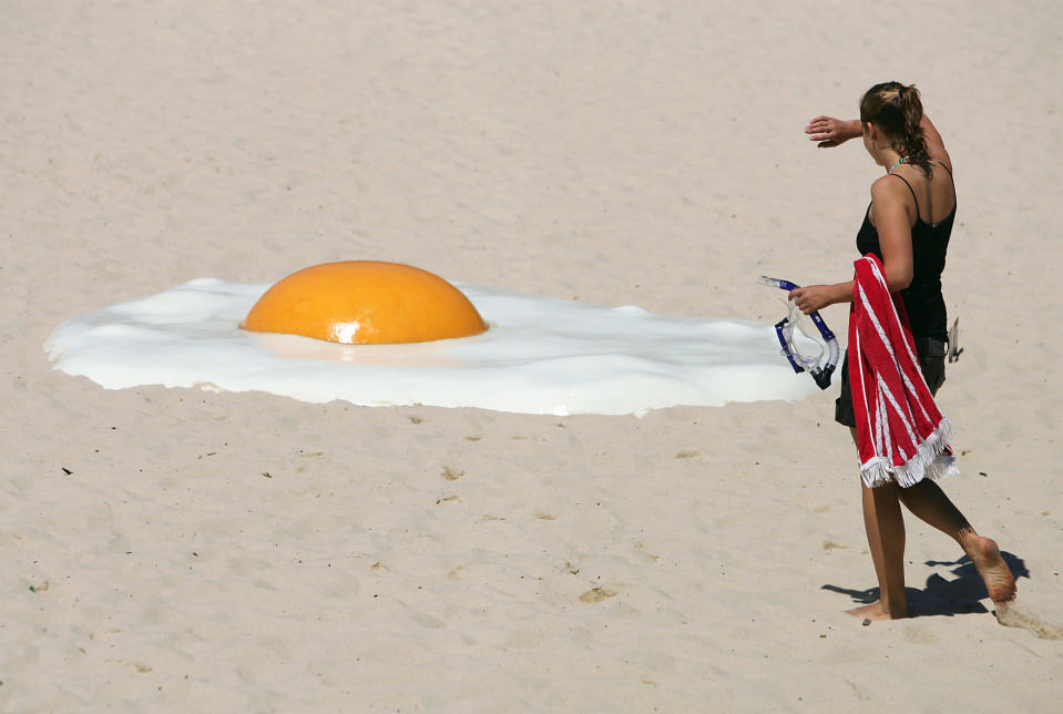 A woman approaches an artwork called "Big Chook", made of fibreglass and high gloss epoxy marine paint, on Tamarama Beach in Sydney November 2, 2005. Australian artist Jeremy Parnell says people frying themselves on the beach for a suntan inspired his piece which joins 100 artworks contributed by international and Australian artists at the annual outdoor Sculpture by the Sea exhibition which is in its ninth year. REUTERS/Will Burgess