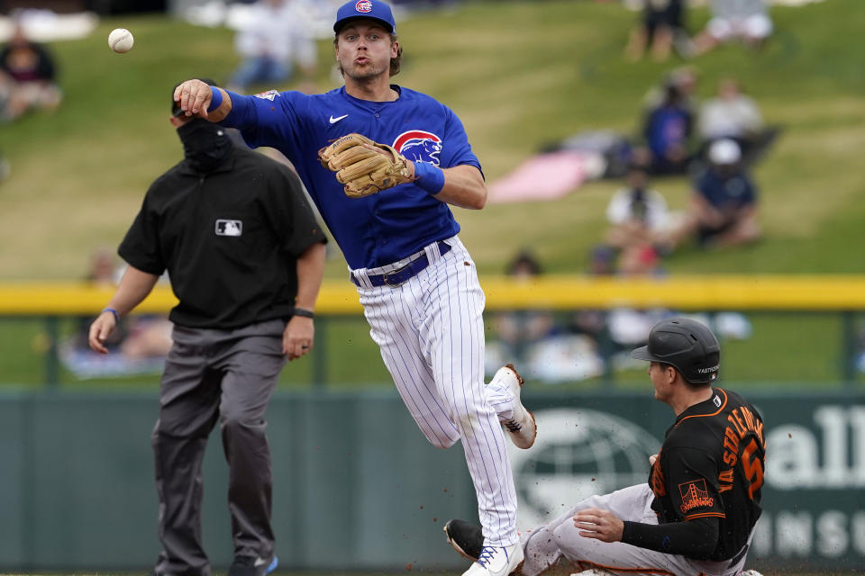 Chicago Cubs' Nico Hoerner forces out San Francisco Giants' Mike Yastrzemski (5) as he turns a double play on Donovan Solano during the second inning of a spring training baseball game, Friday, March 26, 2021, in Mesa, Ariz. (AP Photo/Matt York)