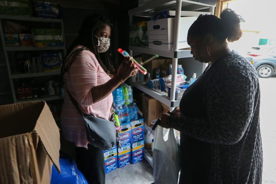 Stacey Henry (left) gives donated supplies to Lenora Jefferson from a shed containing basic products for people forced from their Wilmington homes by the flooding of Sept. 2, 2021. Henry has been organizing donations and providing other assistance to victims of the flood waters that displaced hundreds of Wilmingtonians.