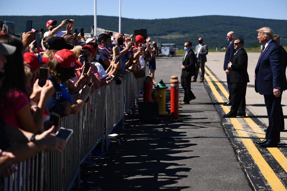 Mr Trump greets supporters upon arrival at Wilkes-Barre Scranton International Airport in Avoca, Pennsylvania (AFP via Getty Images)