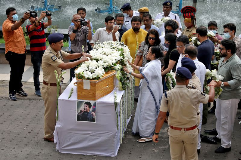 Mamata Banerjee places a wreath on the coffin containing the body of Indian singer before a gun salute in Kolkata