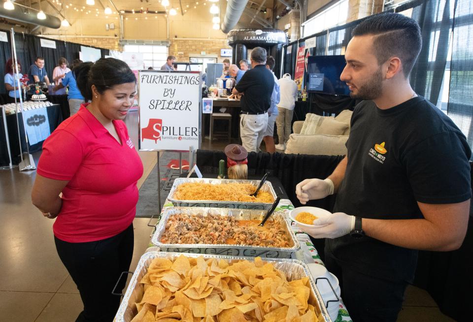 Chevonne Torrance talks to Alex Hernandez of Jalapeno’s restaurant on Jun21, 2022, as he serves up samples during the Celebrate Local event at Tuscaloosa River Market. The event, which will be held this year from 11:30 a.m. until 7 p.m. Tuesday, allows local merchants to showcase their goods to the public.