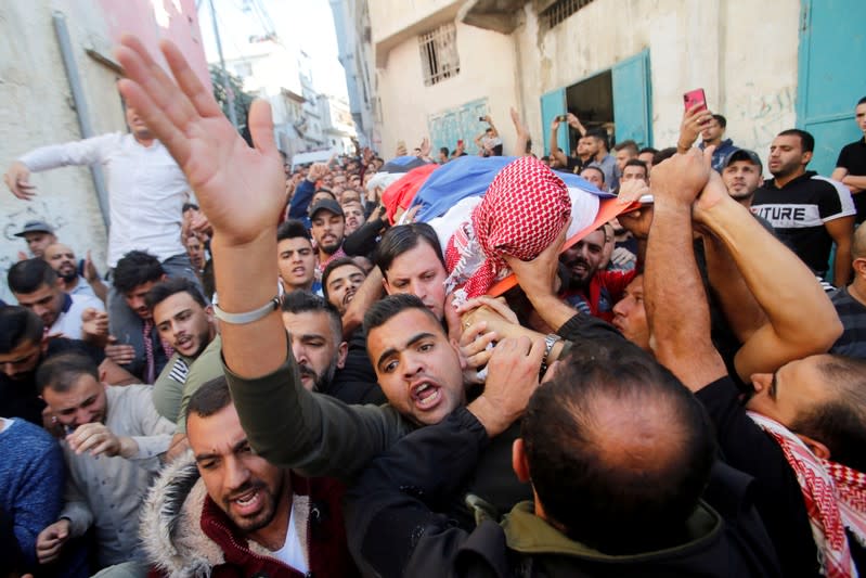 Mourners carry the body of Palestinian man Omar al-Badawi during his funeral in al-Arroub refugee camp, in the Israeli-occupied West Bank