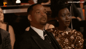 Will Smith and Lupita Nyong'o sitting in an audience as Will shouts at Chris Rock