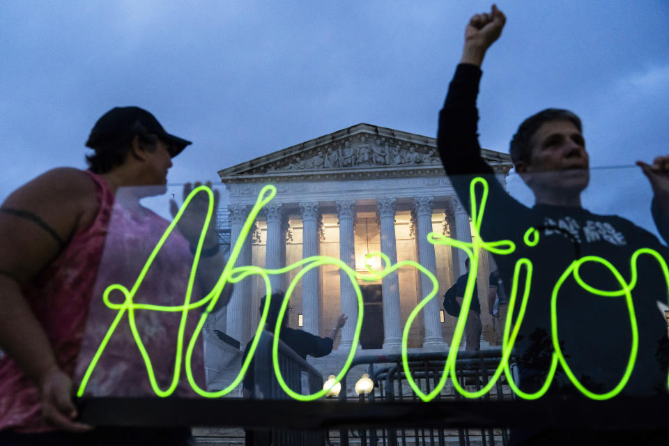 FILE - Activists mark the first anniversary of the Supreme Court's decision in Dobbs v. Jackson Women's Health Organization by displaying neon signage in support of abortion access, June 23, 2023, in Washington. Ever since the nation’s highest court ended abortion rights more than a year ago by overturning Roe v. Wade, vaguely worded bans enacted in some Republican-controlled states have caused bewilderment over how exceptions should be applied. (AP Photo/Nathan Howard, File)