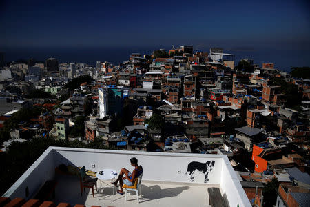 A woman sits on a terrace at Tiki hostel in Cantagalo favela, in Rio de Janeiro, Brazil, April 16, 2016. REUTERS/Pilar Olivares