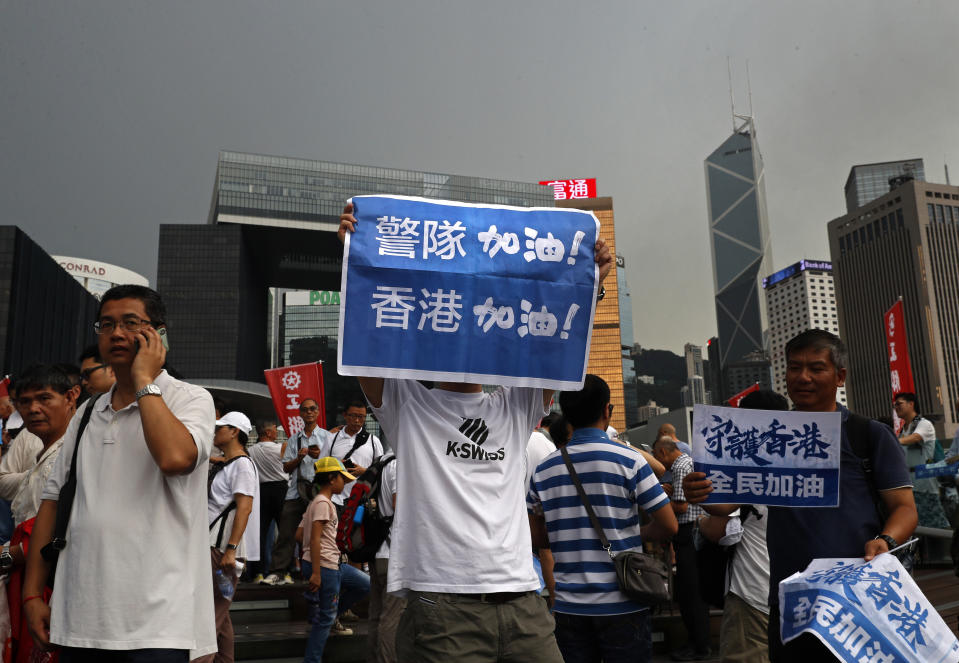 CORRECTS TRANSLATION - Pro-China supporters raises a placard reads" Go Police !" during a counter-rally in support of the police in Hong Kong Saturday, July 20, 2019. Police in Hong Kong have raided a homemade-explosives manufacturing lab ahead of another weekend of protests in the semi-autonomous Chinese territory. (AP Photo/Vincent Yu)