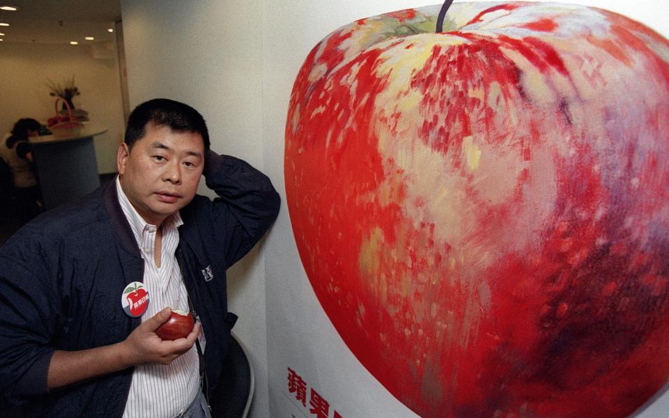 Hong Kong media tycoon Jimmy Lai posing at Apple Daily's new office in June 1995. Now, he is in jail and the paper is shutting down. - Mike CLARKE/ AFP