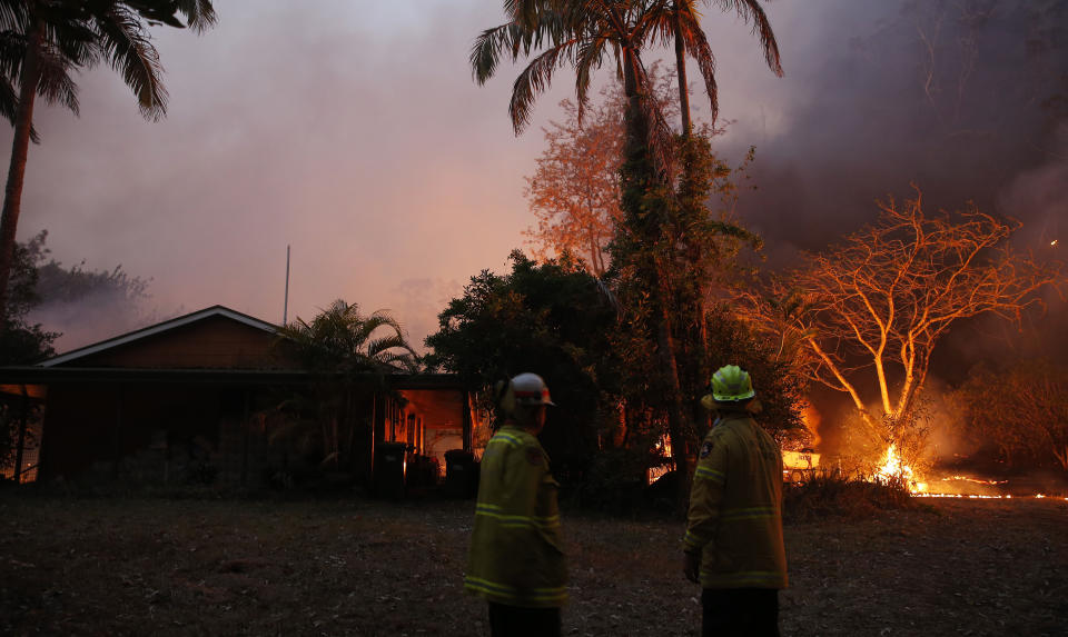 A bushfire in Hillville moves in on a house near the Pacific Highway, north of Nabiac in the Mid North Coast region of NSW on Tuesday. Source: AAP