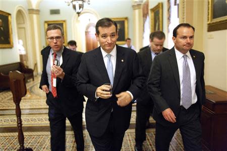 U.S. Senator Ted Cruz (R-TX) (C) and Senator Mike Lee (R-UT) (R) depart the Senate floor after their speeches before the night-time budget vote at the U.S. Capitol in Washington, October 16, 2013. REUTERS/Jonathan Ernst