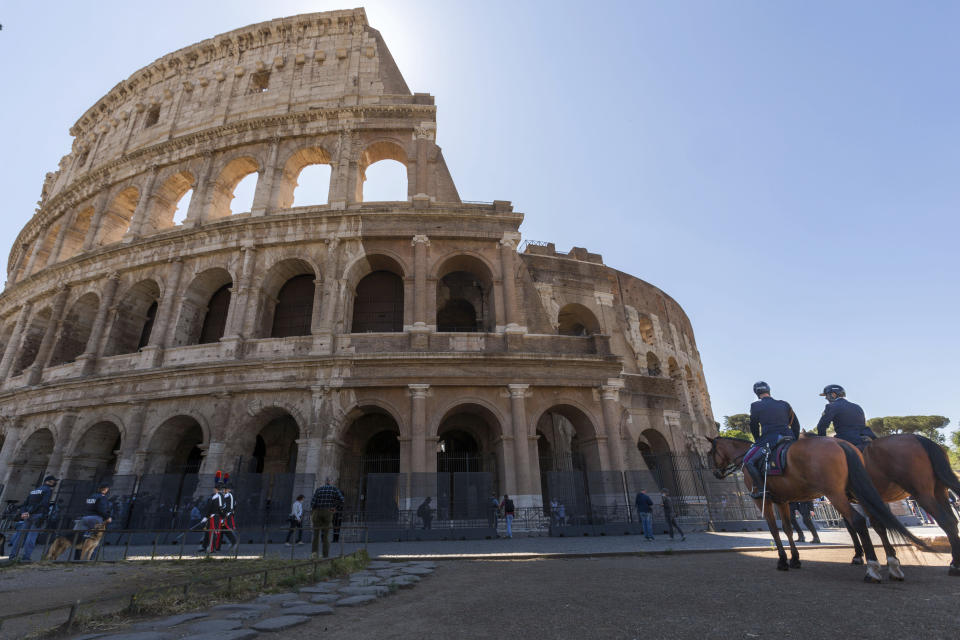 Mounted policemen, right, and Carabinieri in high uniform, left, patrol outside the Colosseum in Rome, Monday, June 1, 2020, during the reopening to the public of one of Italy's most visited monument, after more of two months of lockdown for the coronavirus pandemics. The Colosseum, Palatine, Roman Forum and Domus Aurea reopens to the public on 1 June with some access restrictions for visitors. (AP Photo/Domenico Stinellis)