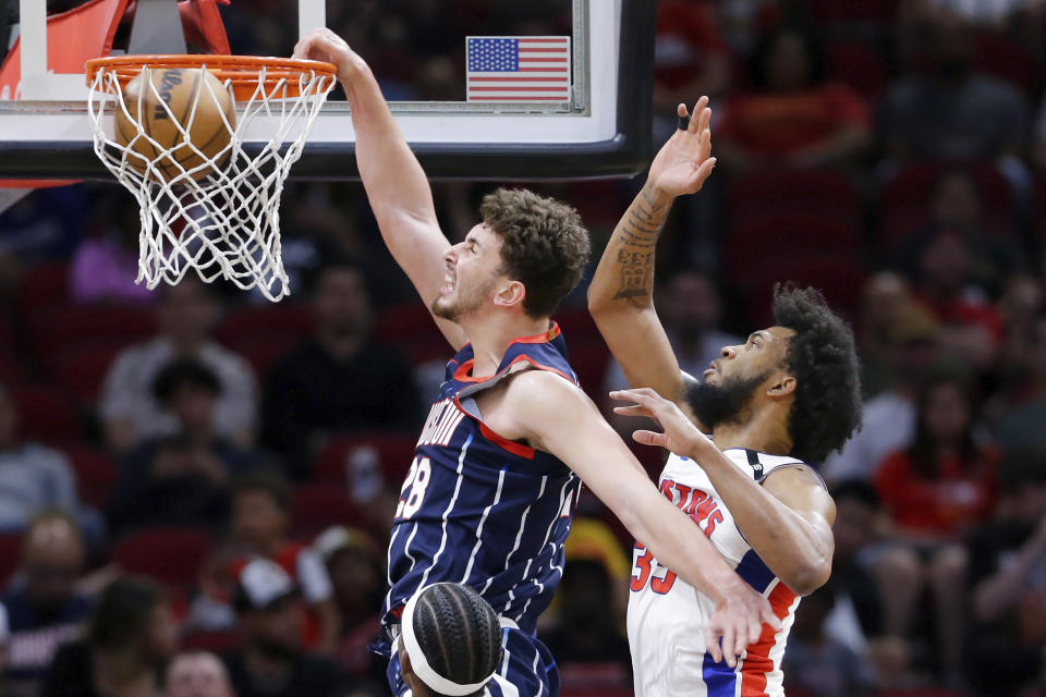 Houston Rockets center Alperen Sengun, left, dunks in front of Detroit Pistons forward Marvin Bagley III, right, during the first half of an NBA basketball game Friday, March 31, 2023, in Houston. (AP Photo/Michael Wyke)