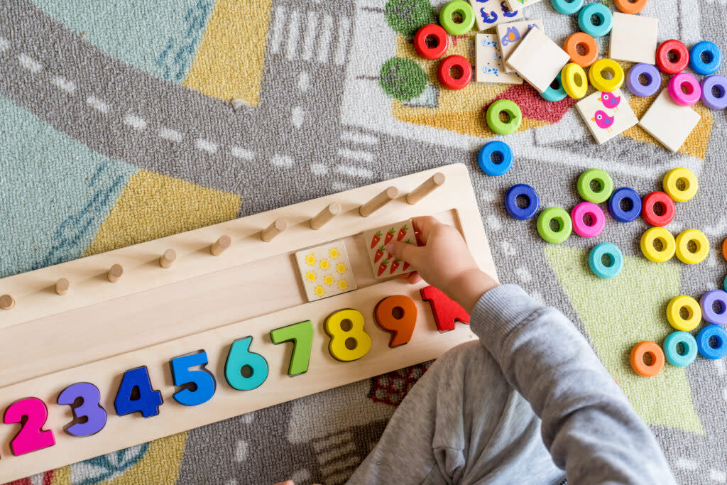 a child's hand touches an instructional puzzle