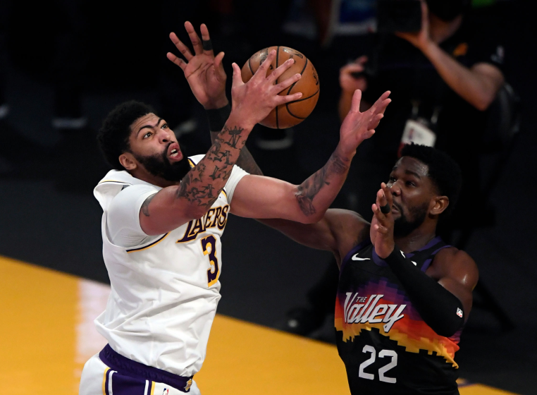 Anthony Davis #3 of the Los Angeles Lakers pulls down a defensive rebound against Deandre Ayton.