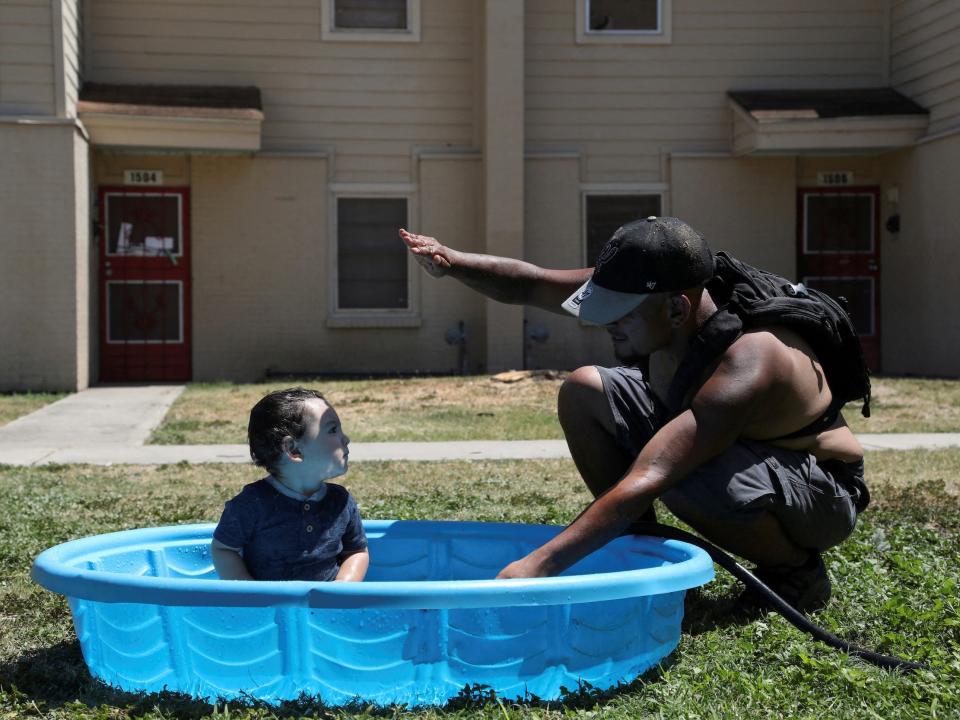 man shields baby's fun from the sun in kiddie pool