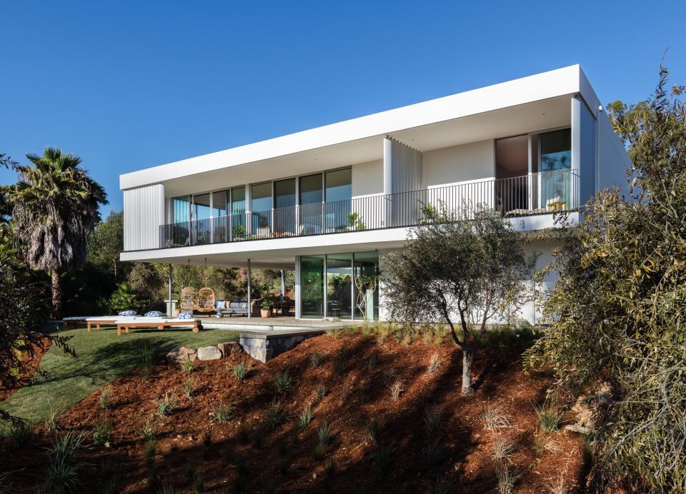 The 3,800-square foot residence sits on a sloped corner of the 3.7-acre property with structural steel columns that float the main living area. Nestled among the owner’s horse stables, the cantilevered stone-and-steel structure includes expansive floor-to-ceiling windows.