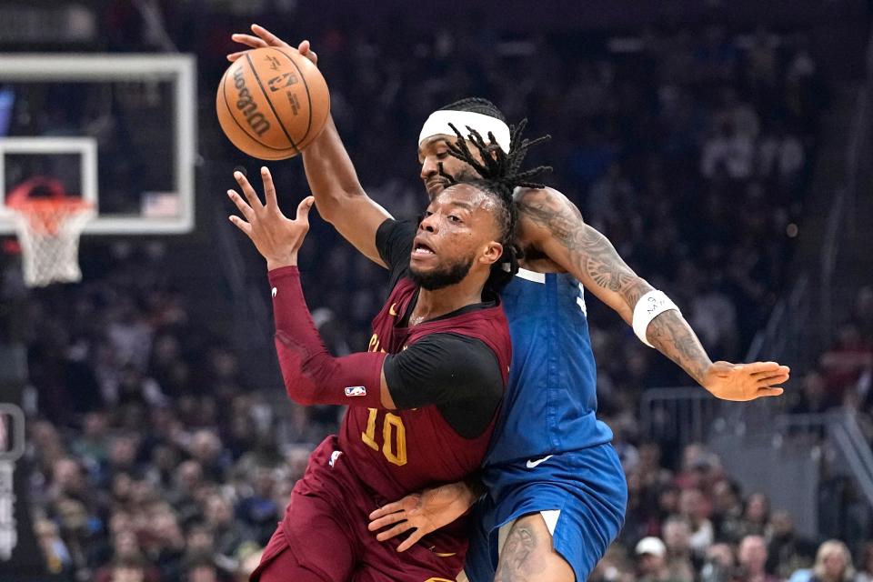 Cleveland Cavaliers guard Darius Garland (10) drives past Minnesota Timberwolves guard Nickeil Alexander-Walker during the first half of an NBA basketball game Friday, March 8, 2024, in Cleveland. (AP Photo/Sue Ogrocki)