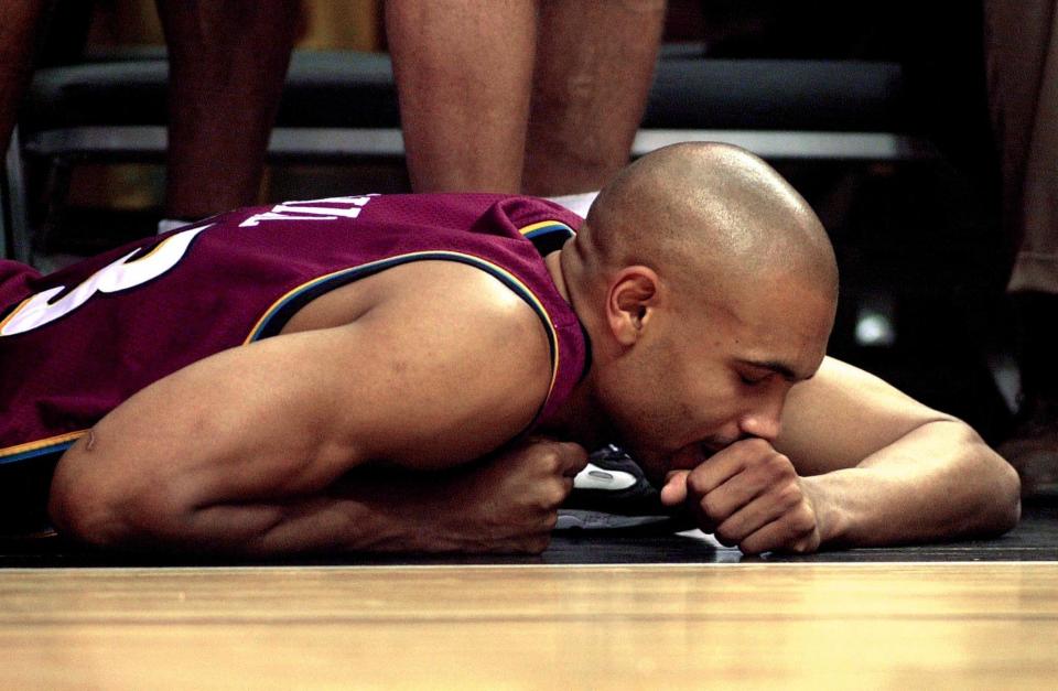 A benched Grant Hill closes his eyes on the floor of American Airlines Arena in the final seconds of Game 2 of the Pistons’ 2000 first-round playoff series against the Heat. Hill left game after hurting his ankle. (Roberto Schmidt/AFP/Getty Images)