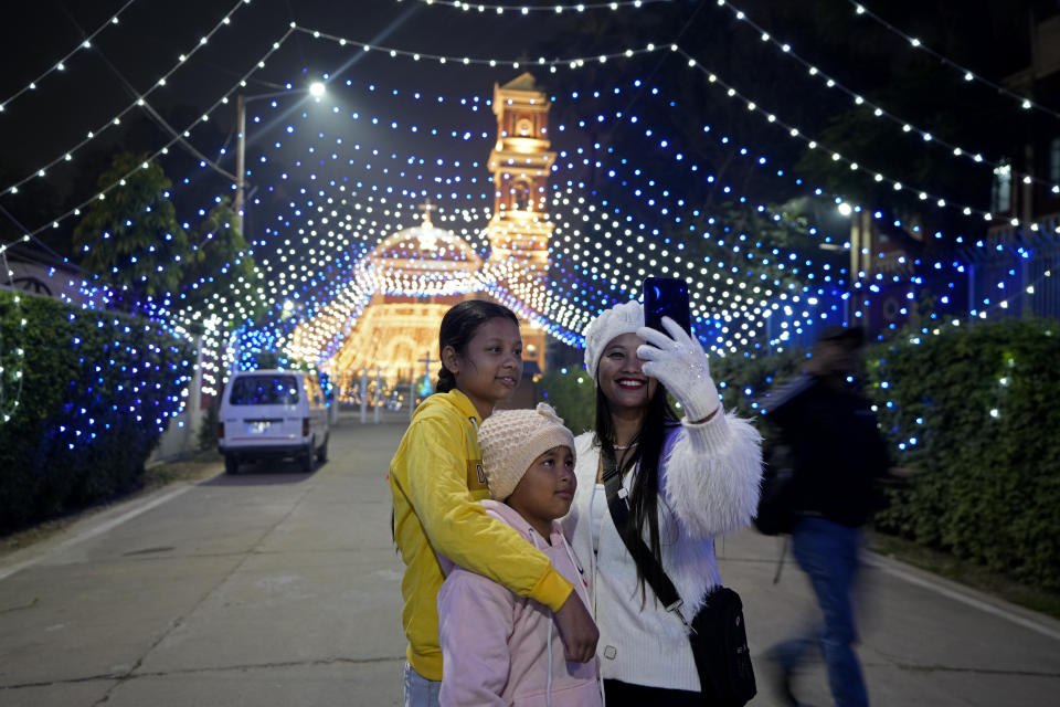 People take selfies in front of the decorated St. Joseph's Cathedral on the eve of Christmas in Prayagraj, India, Sunday, Dec. 24, 2023. Although Christians comprise only two percent of the population Christmas is a national holiday and is observed across the country as an occasion to celebrate. (AP Photo/Rajesh Kumar Singh)