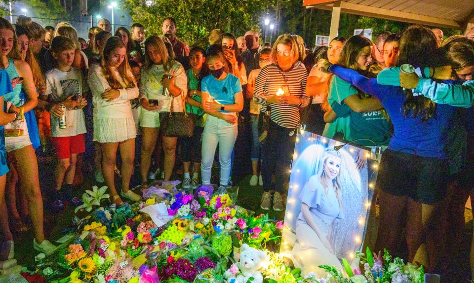 Classmates, friends and neighbors gather around a memorial to slain 13-year-old Tristyn Bailey after a gathering to remember her at a Durbin Crossing community center in May.