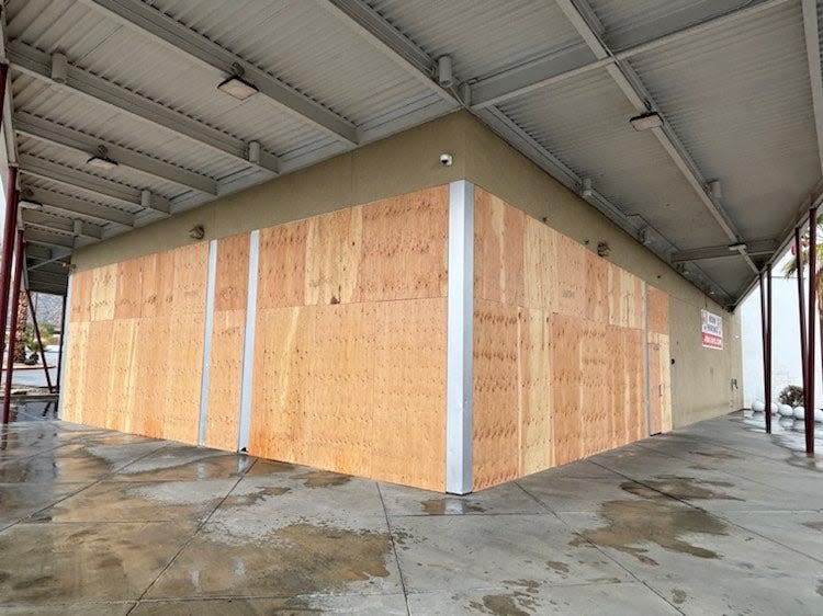 Wood boards cover the windows of what was formerly a KFC restaurant in Palm Springs.