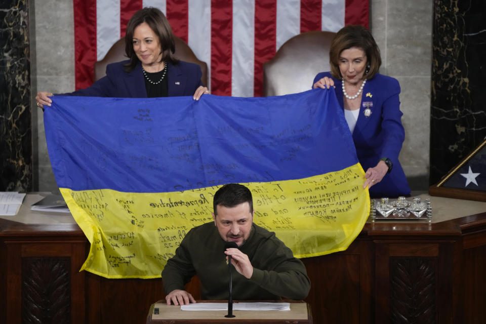 Vice President Kamala Harris and House Speaker Nancy Pelosi of Calif., right, hold up a Ukrainian flag autographed by front-line troops in Bakhmut, in Ukraine's contested Donetsk province, after Ukrainian President Volodymyr Zelenskyyas addressed a joint meeting of Congress on Capitol Hill in Washington, Wednesday, Dec. 21, 2022.(AP Photo/Jacquelyn Martin)