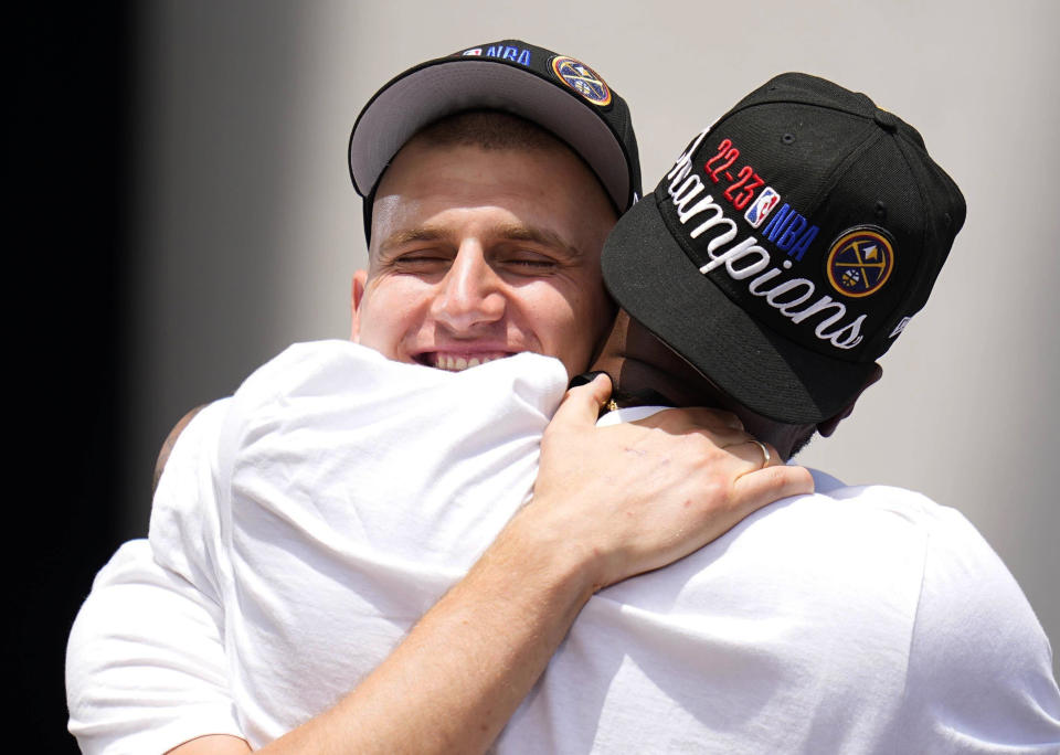 Denver Nuggets center Nikola Jokic hugs a coach during a rally to mark the Denver Nuggets first NBA basketball championship Thursday, June 15, 2023, in Denver. (AP Photo/Jack Dempsey)