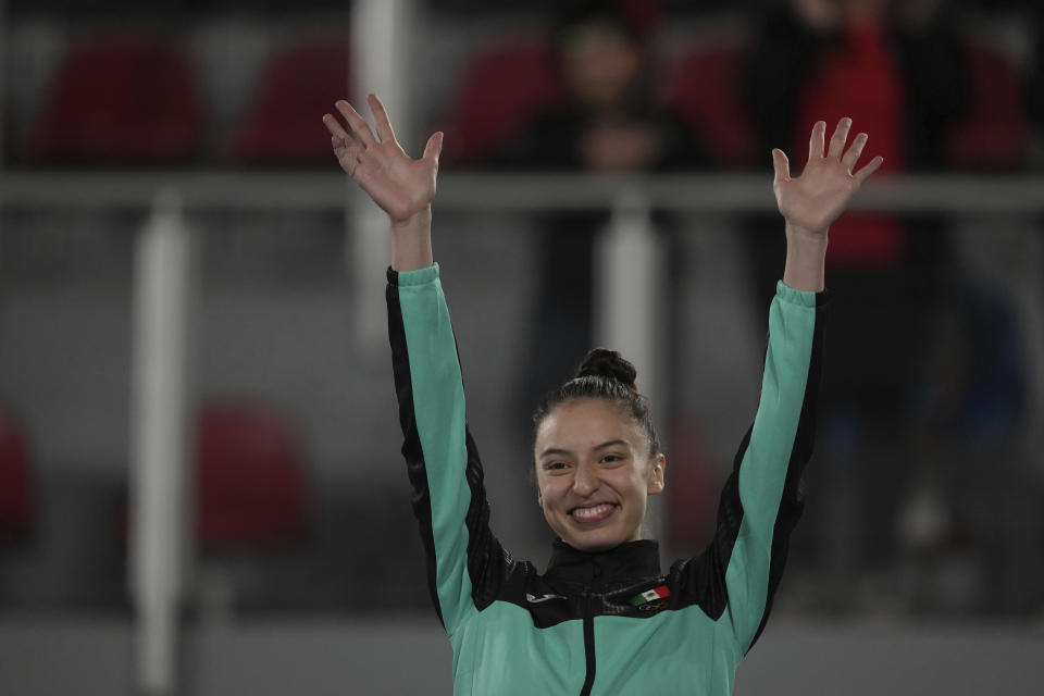 La mexicana Daniela Souza celebra en el podio tras ganar la medalla de oro en la modalidad kyorugi del taekwondo femenino de los Juegos Panamericanos de Santiago, Chile, el sábado 21 de octubre de 2023. (AP Foto/Dolores Ochoa)