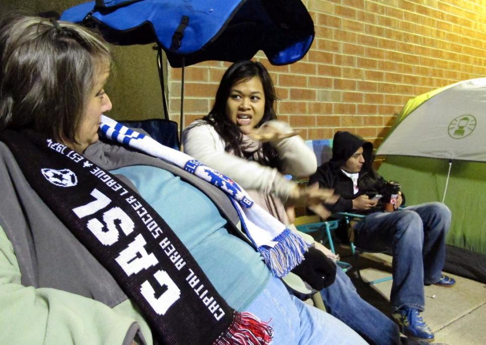 Karen Jefferson, left, chats with Michelle Phan as they wait outside a Best Buy store in Raleigh, N.C., on Thursday, Nov. 22, 2012. The two had been camped out since Wednesday evening, missing Thanksgiving dinners with family in hopes of getting great deals on flat-screen televisions. (AP Photo/Allen Breed)