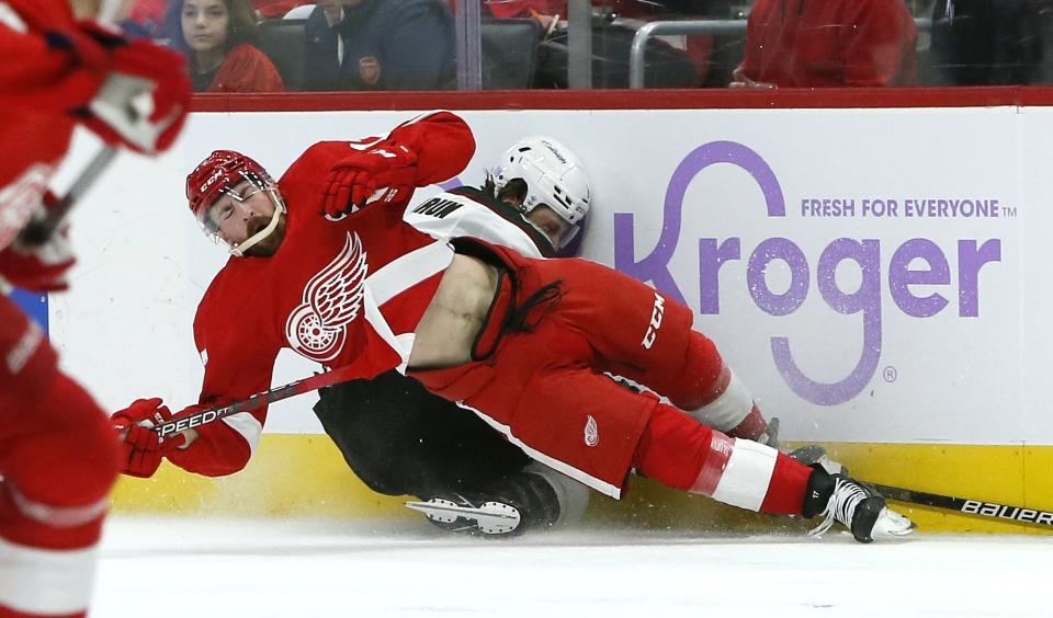 Arizona Coyotes defenseman Jakob Chychrun, right, is crushed against the boards by Detroit Red Wings defenseman Filip Hronek, left, during the second period of an NHL hockey game Friday, Nov. 25, 2022, in Detroit. (AP Photo/Duane Burleson)