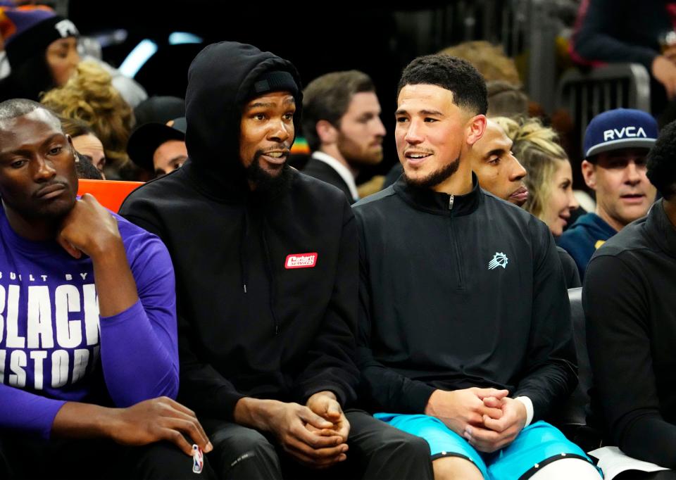 Phoenix Suns forward Kevin Durant (35) talks to Phoenix Suns guard Devin Booker (1) on the bench against the Oklahoma City Thunder in the second half of a Feb. 24, 2023, game at Footprint Center in Phoenix.