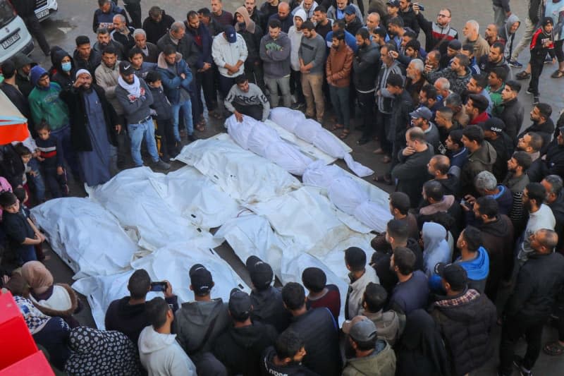 Relatives of Palestinians who were killed in Israeli attacks, mourn as they receive the bodies in the morgue of Al-Aqsa Hospital for burial in Deir El-Balah. Ali Hamad/APA Images via ZUMA Press Wire/dpa